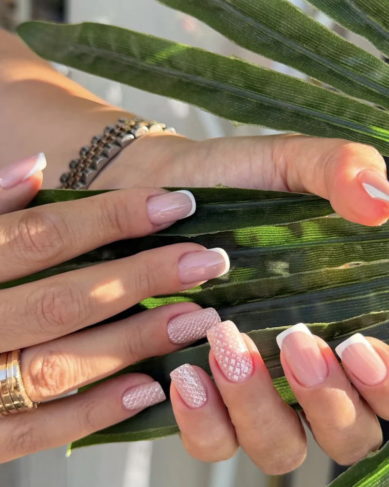 French manucure avec nail art en dentelle, sur une feuille de palmier